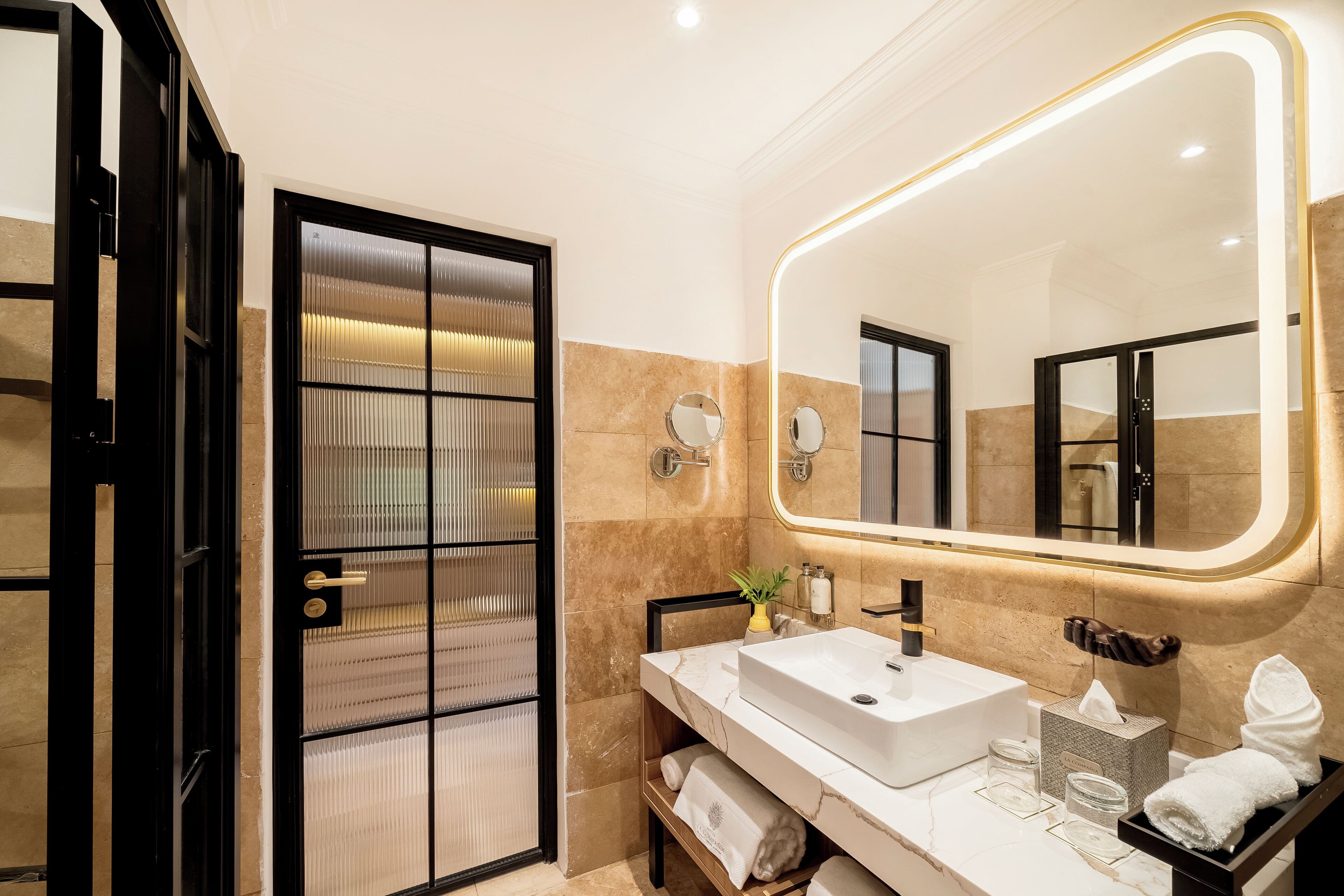 Un baño moderno con un espejo grande, un lavabo y un perchero para toallas.