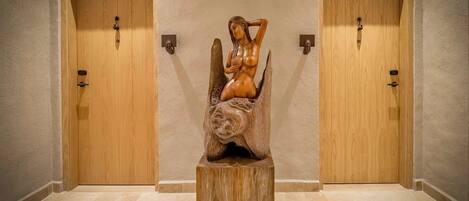 Un pasillo con dos puertas de madera y una escultura de madera en el centro.