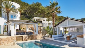 A pool area with a stone deck, outdoor seating, and a pergola. - Beautiful Villa With sea Views (Sant Josep de sa Talaia)