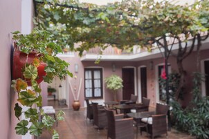 Un cortile con zona pranzo, piante in vaso e una pianta pensile.
