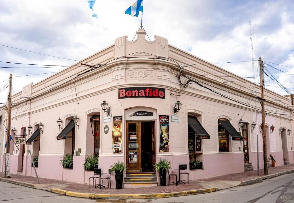A pink building with a sign reading "Bonafide" and a smaller sign "Hotel Plaza" below it.