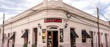 A pink building with a sign reading "Bonafide" and a smaller sign "Hotel Plaza" below it.