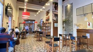 Un restaurant dont le sol est recouvert de motifs, avec des chaises et des tables en bois.