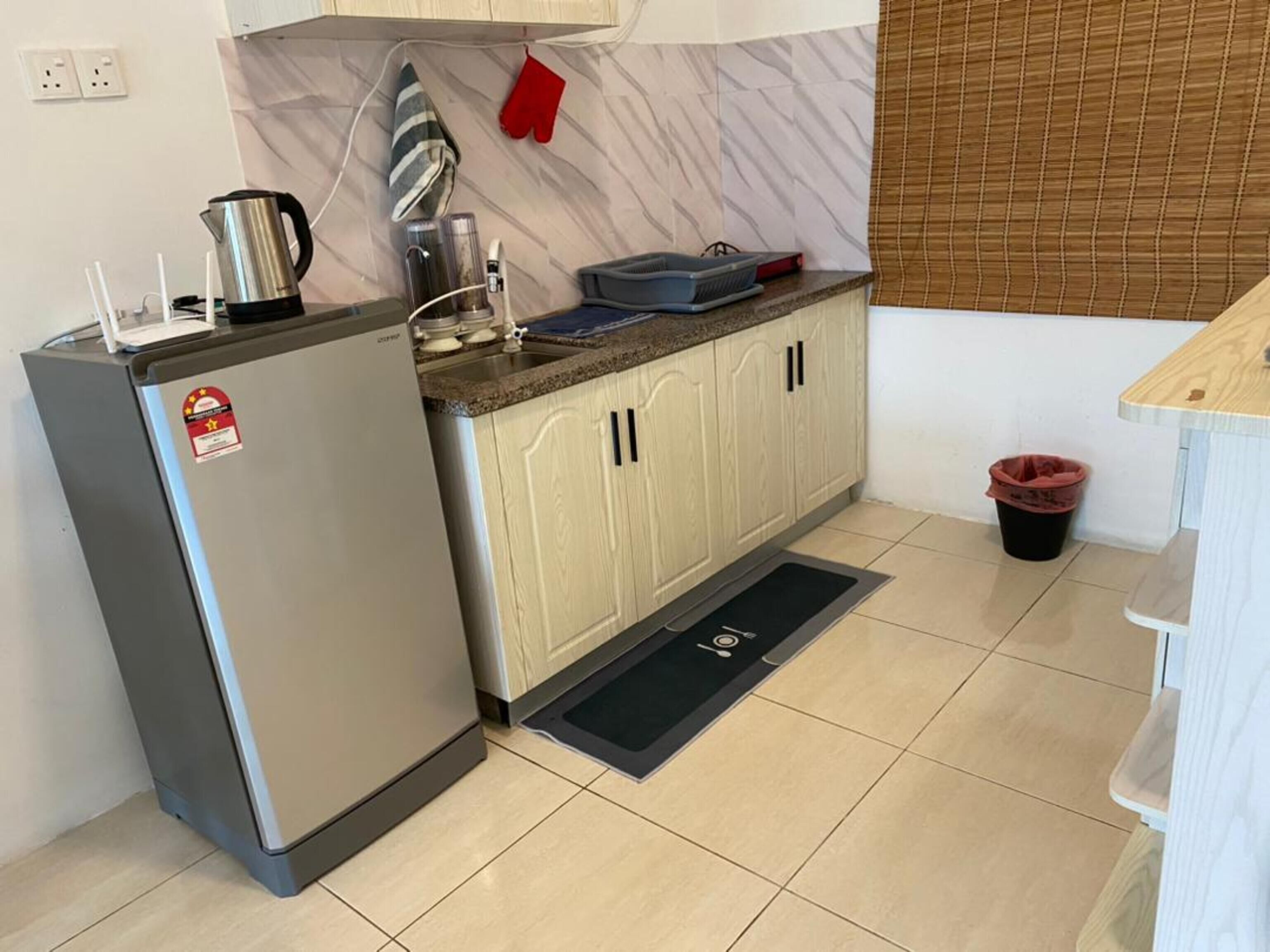 A compact kitchen with a refrigerator, a sink, and a countertop.