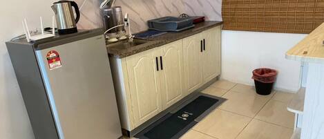 A compact kitchen with a refrigerator, a sink, and a countertop.