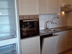 A kitchen with a built-in oven, a sink, and a dish drying rack. - Apartment Lemi - three bedroom apartment with a sea view (Ražanac)