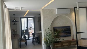 A modern living room with a fireplace, a dining area, and a kitchen in the background. - Villa Marantik - with outdoor pool (Bilice)