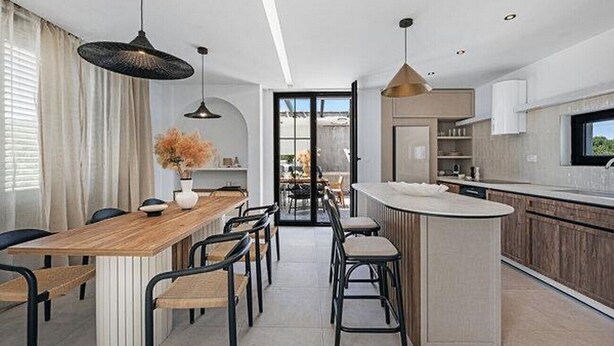 A modern kitchen with a central island, bar stools, pendant lighting, and a view through an open door. - Villa Marantik - with outdoor pool (Bilice)