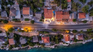Vista aérea de un pueblo costero con casas, una calle principal y una vista despejada del mar.