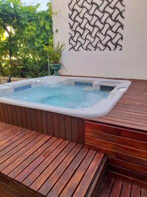 Un jacuzzi con cubierta de madera y un panel decorativo en la pared.