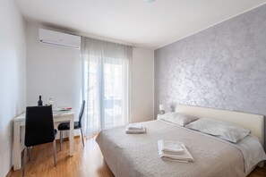 Una habitación de hotel con una cama, un escritorio y una silla.