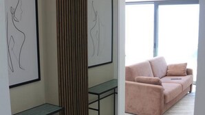 A modern interior with a sofa, framed artwork, and a tall, narrow partition.
