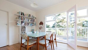 A dining area with a table, chairs, and a bookshelf. - Ipanema (Wye River)