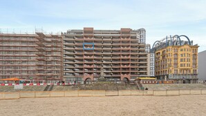 Un edificio a più piani dal design architettonico moderno, caratterizzato da una serie di balconi e un colonnato centrale.