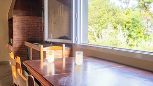 Una cucina con parete in mattoni, una finestra e un tavolo con sedie.