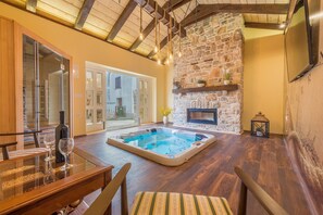 Relax in a spacious indoor area with a large hot tub, fireplace, and TV for a leisurely escape.