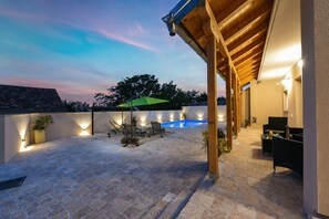 A covered outdoor area with a swimming pool, seating, and ambient lighting. - Villa Outback ZadarVillas (Benkovac)