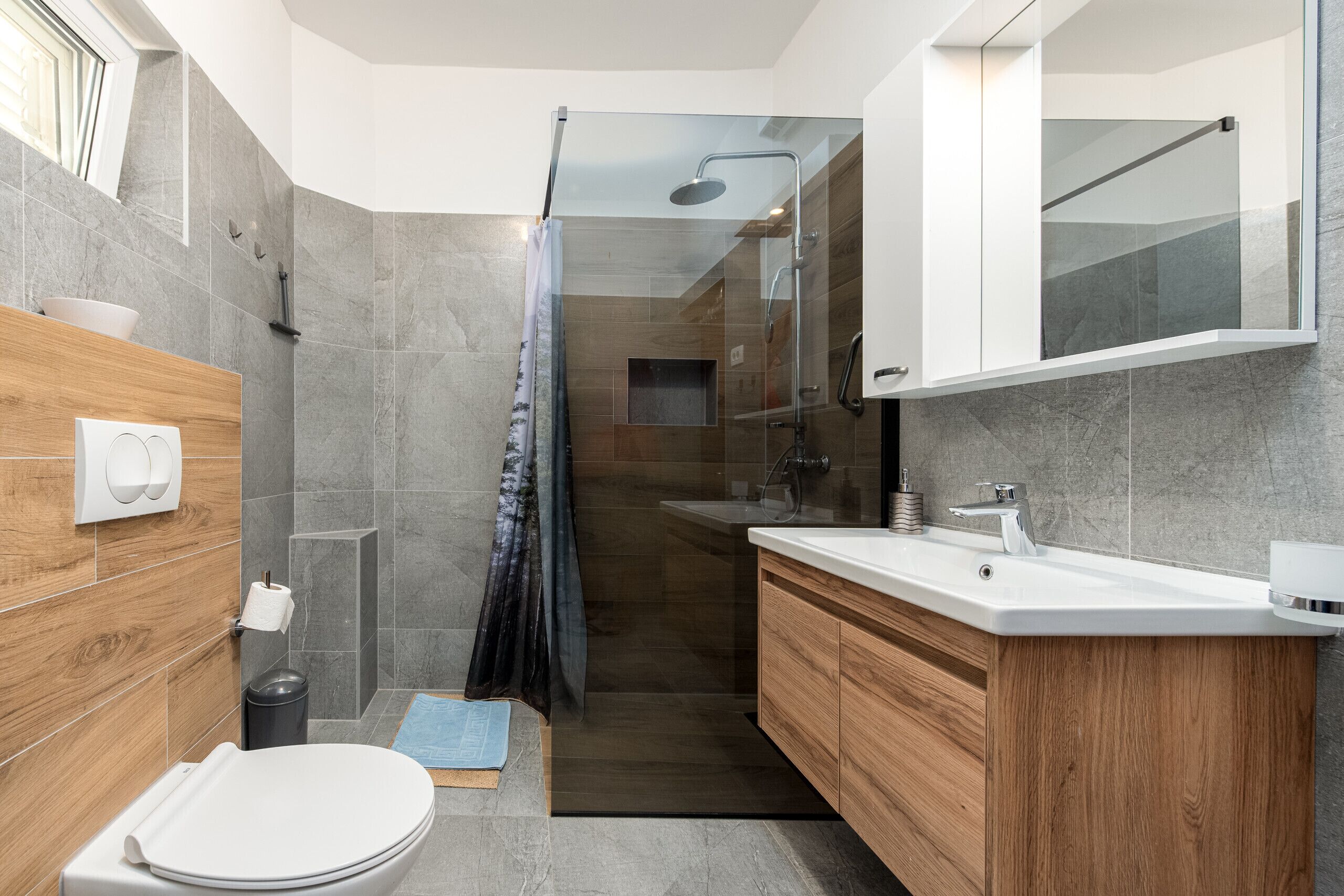 Ein modernes Badezimmer mit Dusche, Toilette und Waschtisch.