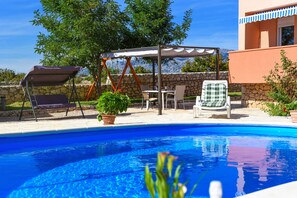A swimming pool with a pergola, outdoor furniture, and a stone wall. - Villa Nea ZadarVillas (Ždrilo)