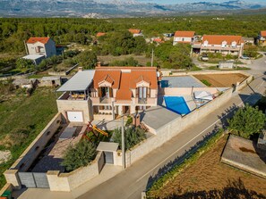 A residential property with a swimming pool, a covered patio, and a view of the surrounding landscape. - Villa Kamen ZadarVillas (Pridraga)