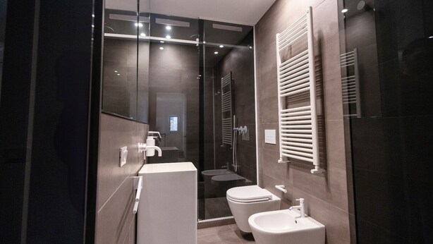 Une salle de bain moderne avec une douche à parois de verre, un lavabo blanc et des toilettes.