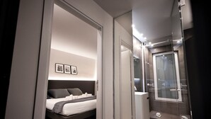 Une chambre à coucher moderne avec un lit, des tables de chevet et un grand miroir.