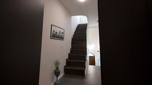 A staircase leading to a landing with a framed picture on the wall and a potted plant beside it. - La mia terra Boutique Rooms (Palermo)