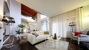 A spacious living room with a white sofa, a coffee table, and a dining area with a chandelier. - Villa Amarena ZadarVillas (Zadar)