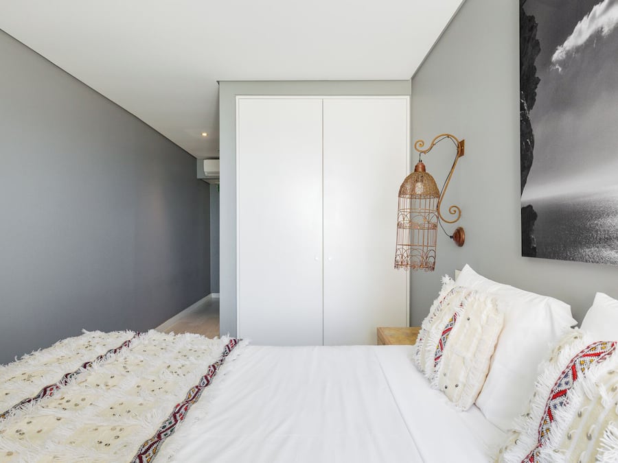 Un dormitorio con una cama grande, una lámpara colgante y un cuadro en la pared.