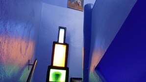 Eine Treppe mit gemusterten Fliesen, einer Wandleuchte und einem kleinen Fenster.