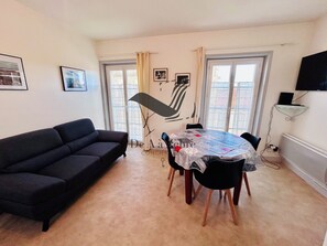 Relax in a cozy seating area with a sofa and enjoy meals at the central dining table.