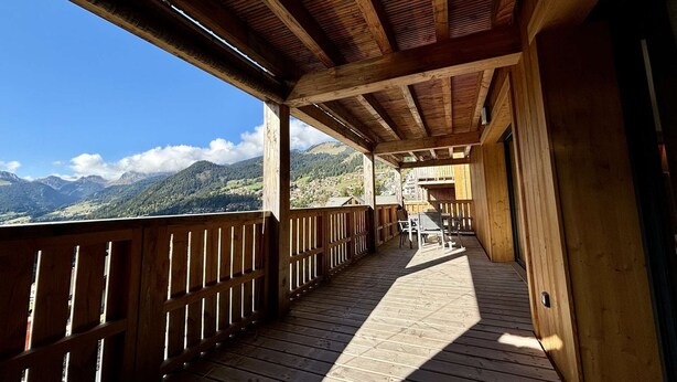 A wooden deck with a view of mountains. - Large, bright T4 in the heart of Châtel (CHATEL)