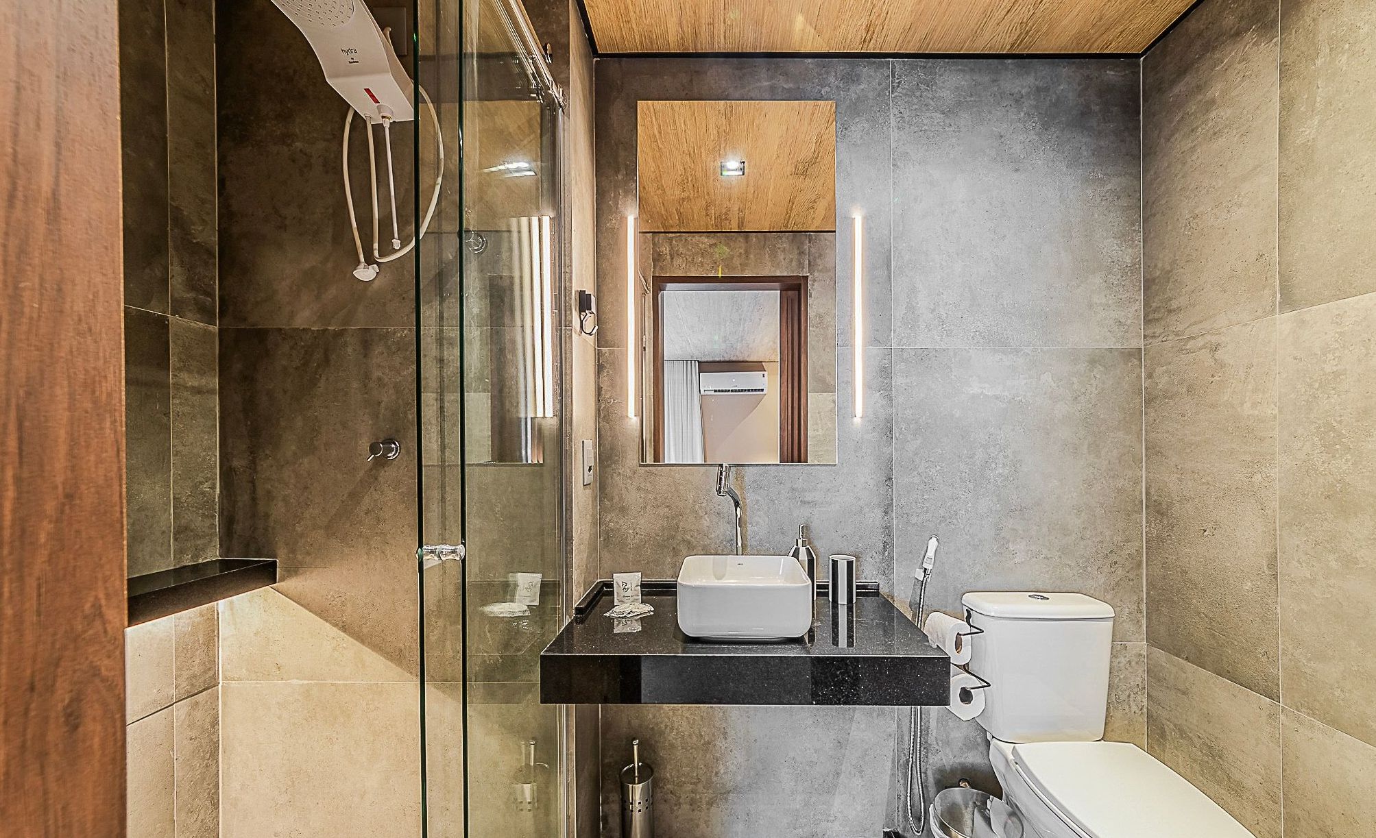 Een moderne badkamer met een glazen douchecabine, een ingebouwd wastafelmeubel en een toilet.