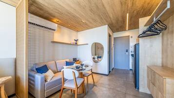 Una cocina moderna con refrigerador empotrado, armarios de madera y un comedor con mesa y sillas blancas.