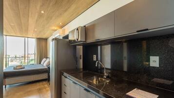 Una cocina moderna con horno integrado, un lavamanos de acero inoxidable y una ventana con vistas a la ciudad.
