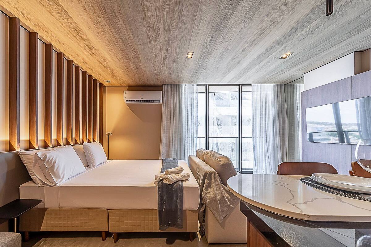 Une chambre d’hôtel moderne avec un grand lit, une table à manger et une vue sur la ville.