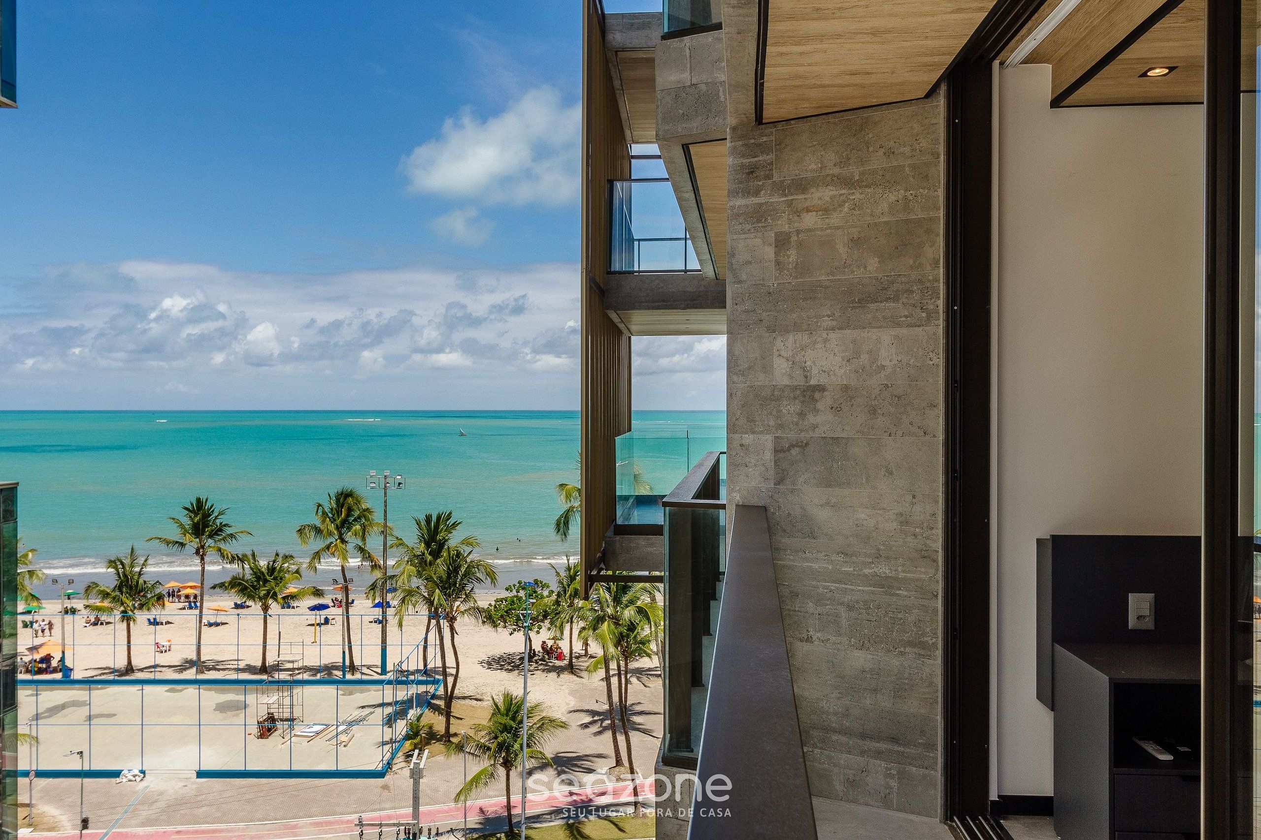 A modern building with a view of a beach and ocean.