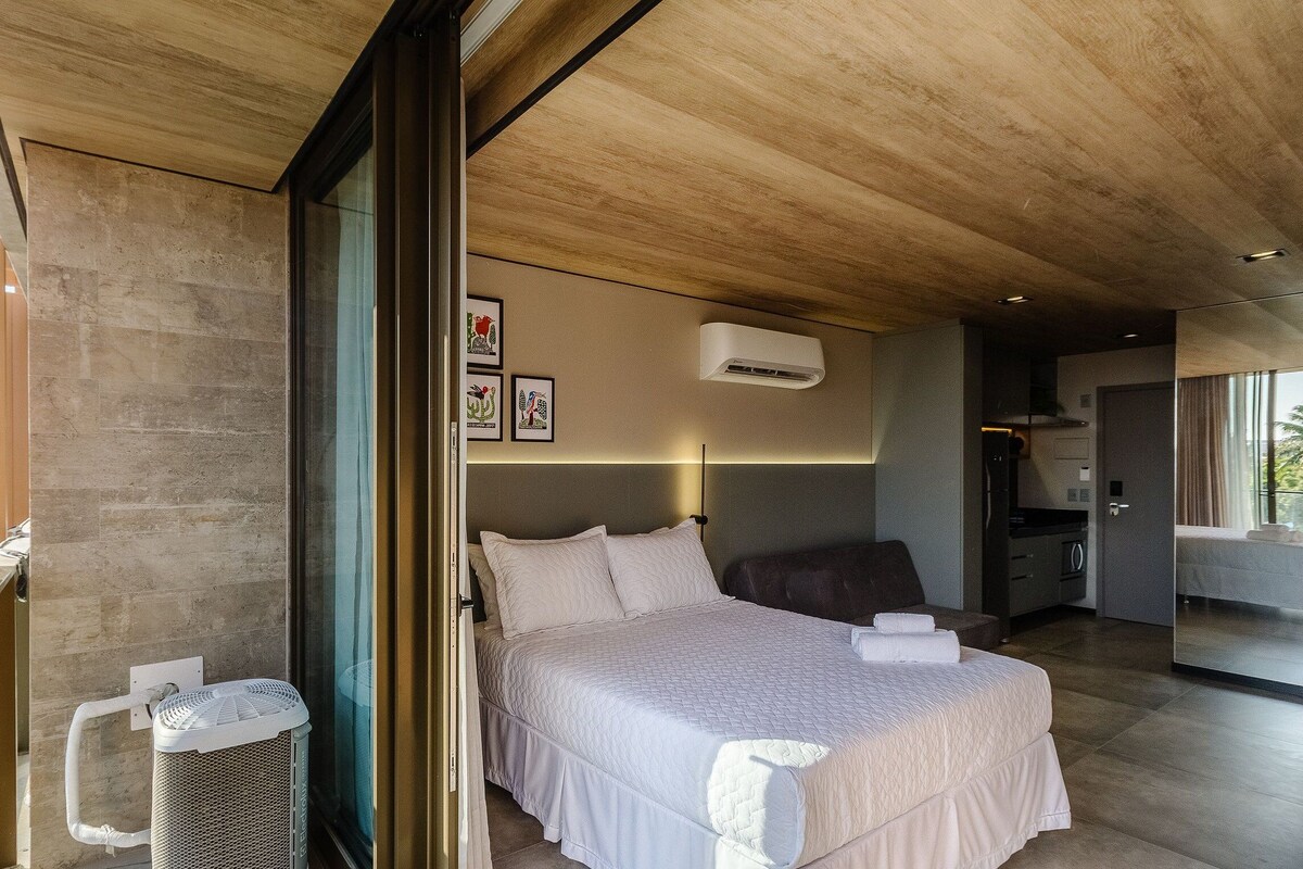 Ein modernes Schlafzimmer mit einem großen Bett, einem Deckenventilator und einem Fenster.