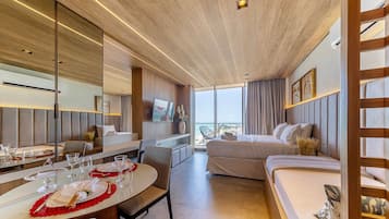 A modern hotel room with a dining area, a bed, and a large window offering a view.