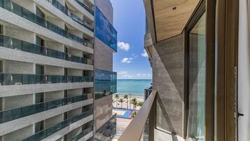 Un edificio alto con varios balcones que dan a una playa.