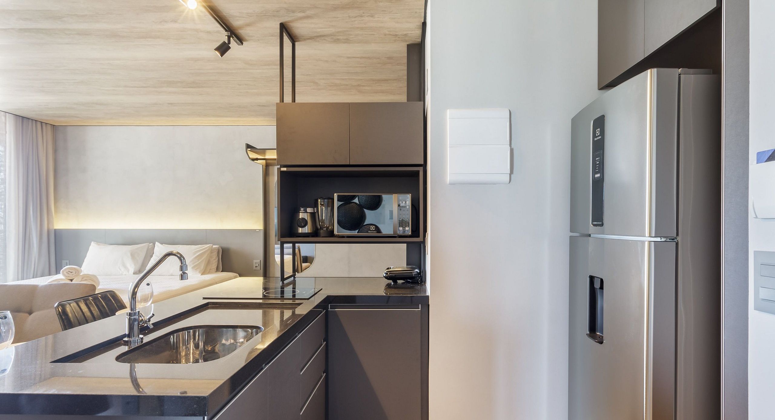 Una cocina moderna con refrigerador integrado, un lavamanos y una encimera.