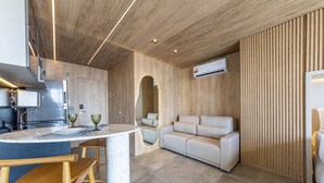 Eine moderne Küche mit Einbauherd, ein Essbereich mit Marmortisch und eine Sitzecke mit Sofa.