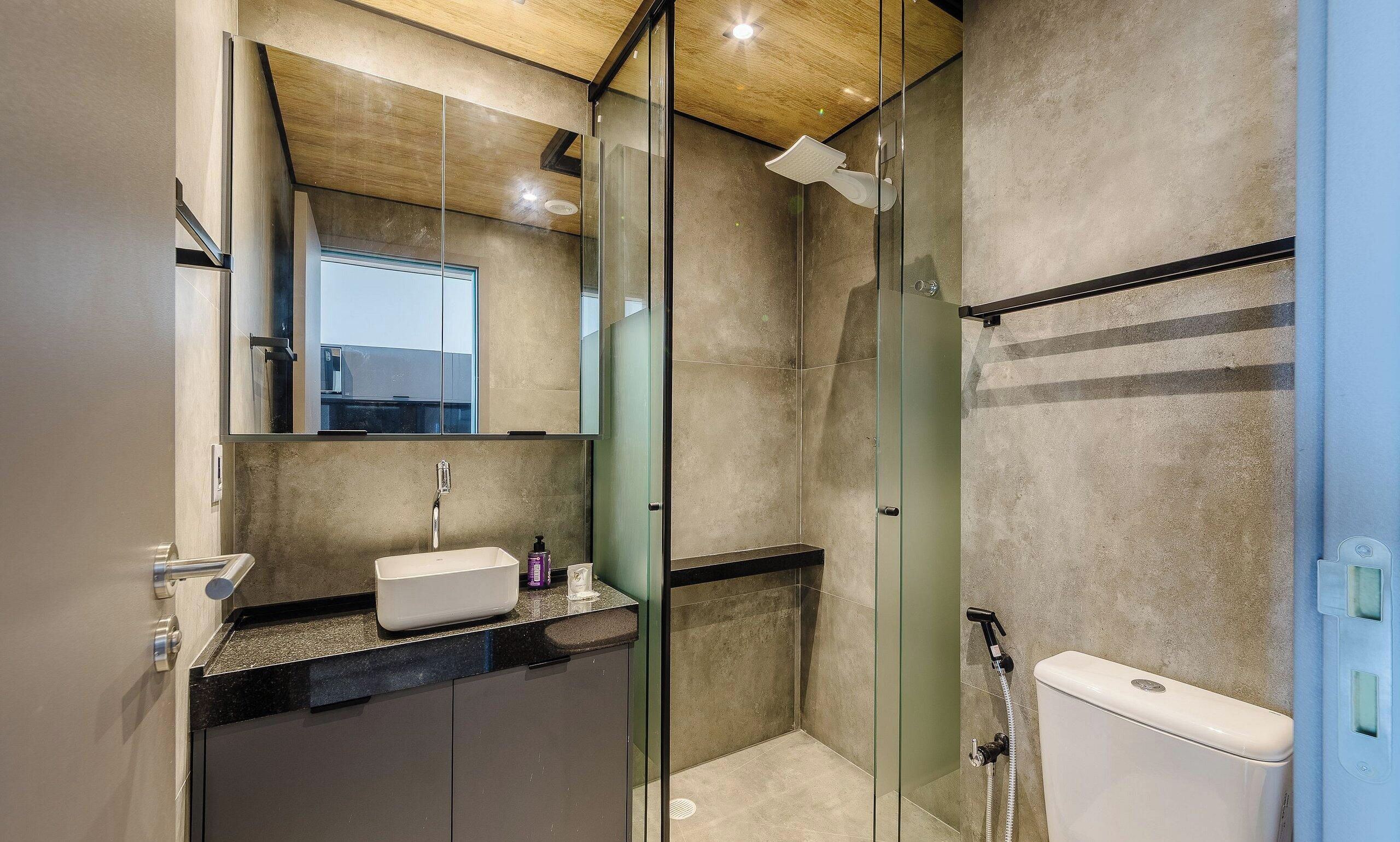 Un bagno moderno con cabina doccia in vetro, lavabo con specchio e water.