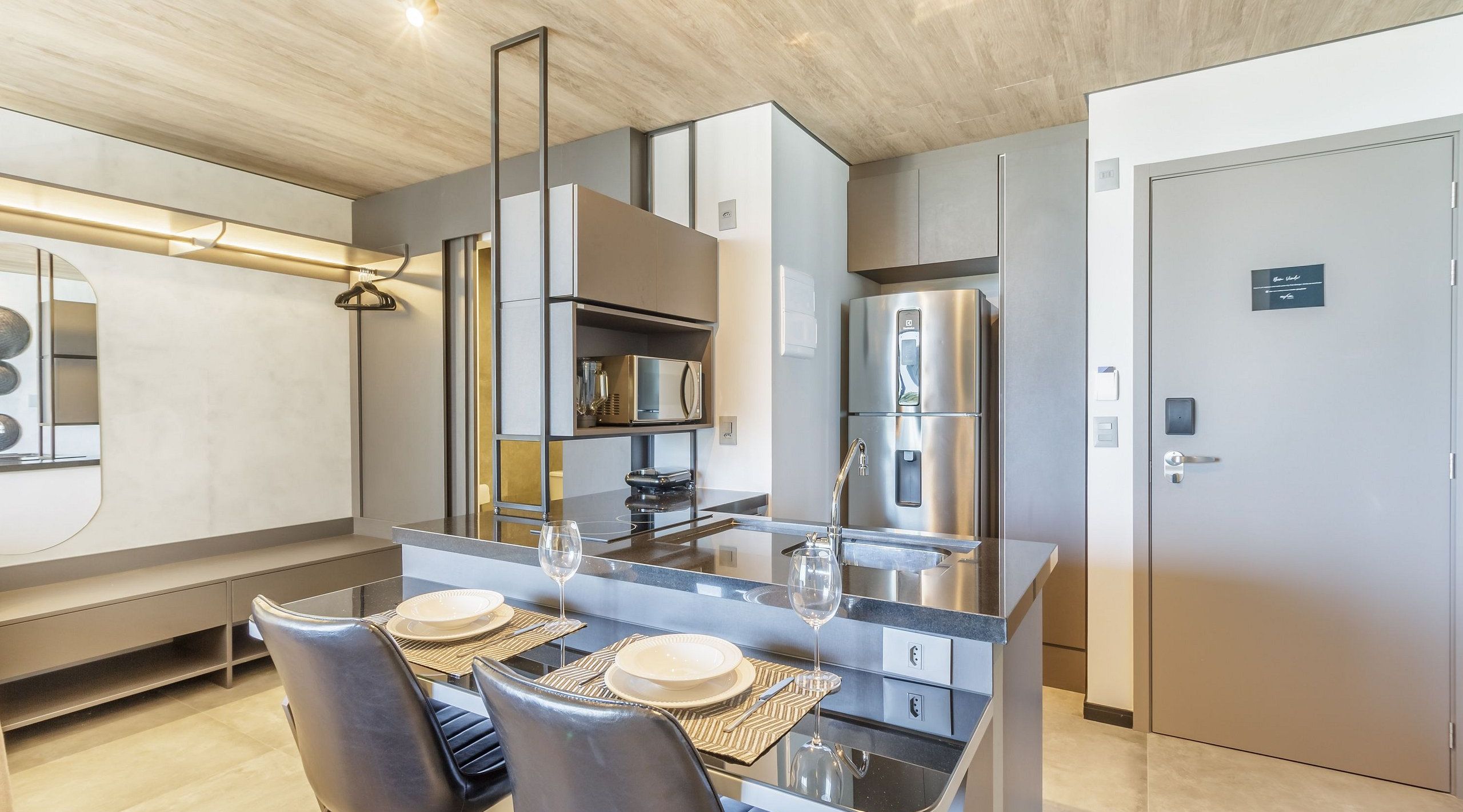 A modern kitchen with a central island, stainless steel appliances, and a dining area with a glass table and chairs.