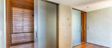 Un pasillo con puerta corredera, suelo de madera y pared de color claro.