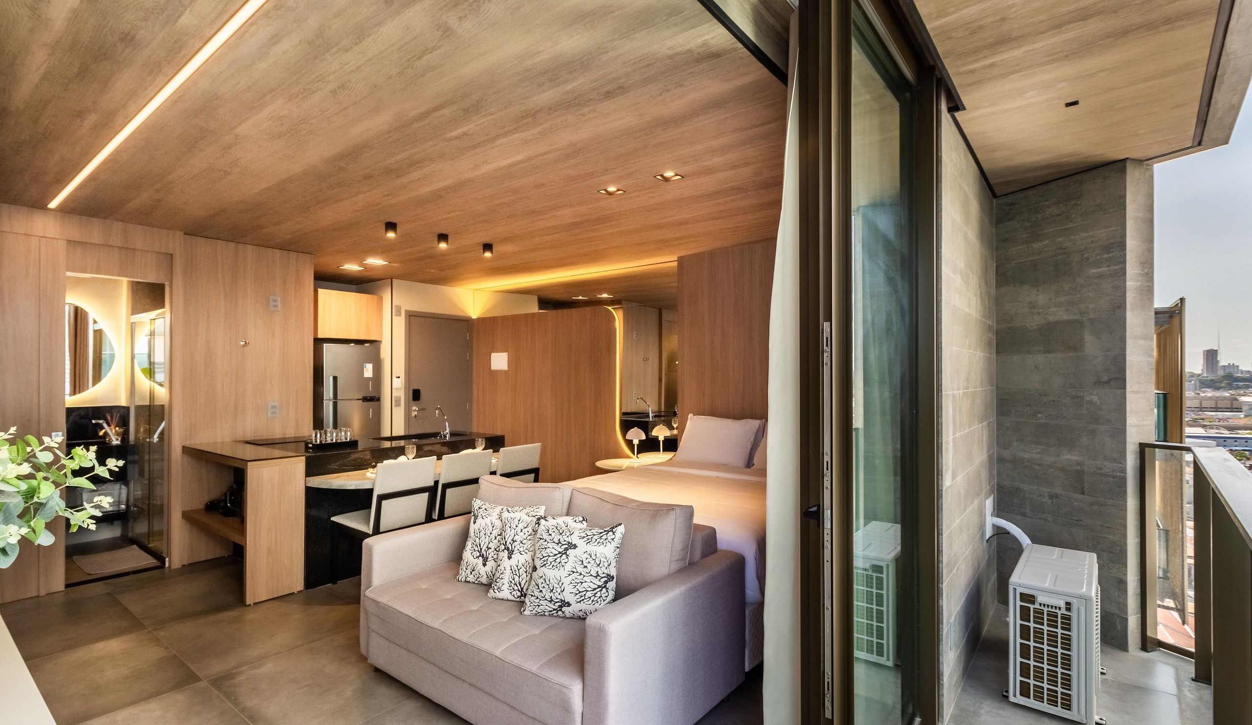 Un interior moderno con cocina, comedor y sala de estar con sofá y cama.