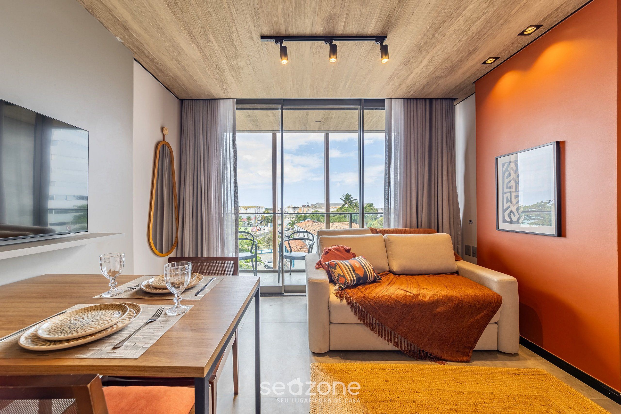Una sala de estar moderna con comedor, ventanas amplias y vistas al exterior.