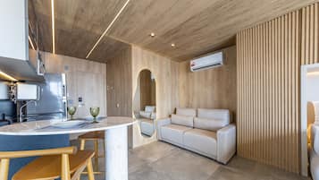 Eine moderne Küche mit Einbauofen, ein Essbereich mit Marmortisch und eine Sitzecke mit Sofa.