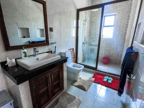 A bathroom with a sink, mirror, toilet, and shower area. - Pv 22 at Pazuri Holidays (Kibaoni)