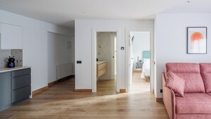 A modern apartment with a kitchen, a living area, and a bathroom.